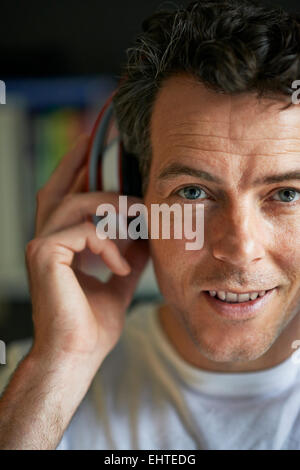 Smiling man with headphones on, close up Stock Photo