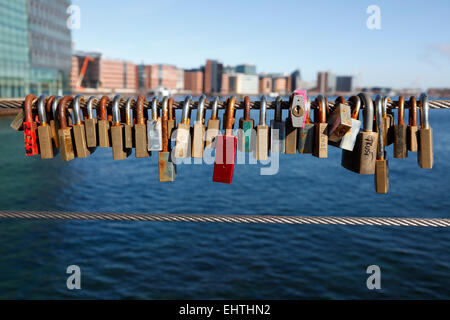 Love locks on the combined bicycle and walkway steel bridge, Bryggebroen, across the southern part of the port of Copenhagen. Stock Photo