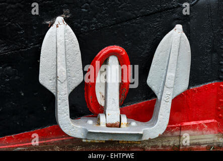 White anchor on a black and red ship. Stock Photo