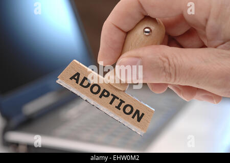 rubber stamp in hand marked with adoption Stock Photo
