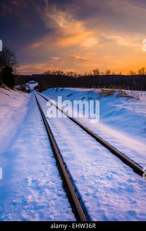 Sunset over snow-covered railroad tracks in Carroll County, Maryland. Stock Photo