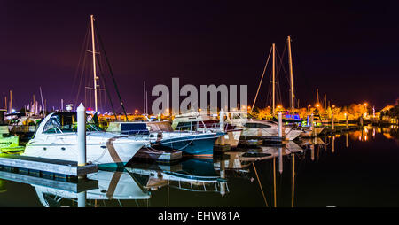 Boats reflecting in the water at night, in a marina on Kent Island, Maryland. Stock Photo