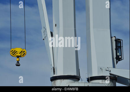 Close-up, detail, heavy duty yellow cargo hook of ship crane suspended in midair, object, background Stock Photo