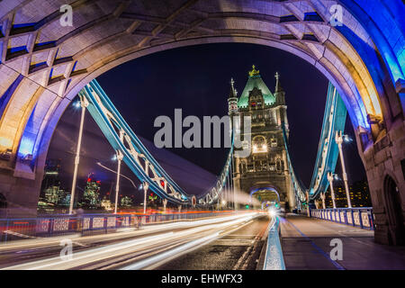 Dramatic night shot of Tower Bridge, London, with light trails through arch. Stock Photo