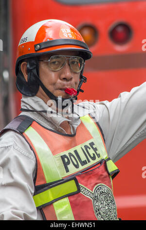 Bangkok, Thailand Nov 28th 2014: A traffic cop with whistle. Police regularly direct traffic in busy areas. Stock Photo