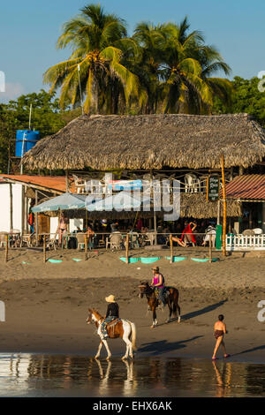 Horse riding on Poneloya Beach, a popular little Pacific Coast resort west of northern city of Leon; Poneloya, Leon, Nicaragua. Stock Photo