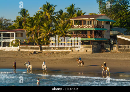 Horse riding on Poneloya Beach, a popular little Pacific Coast resort  west of the northern city of Leon; Leon, Nicaragua. Stock Photo