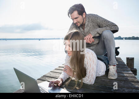 Smiling young couple outdoors working laptop Stock Photo