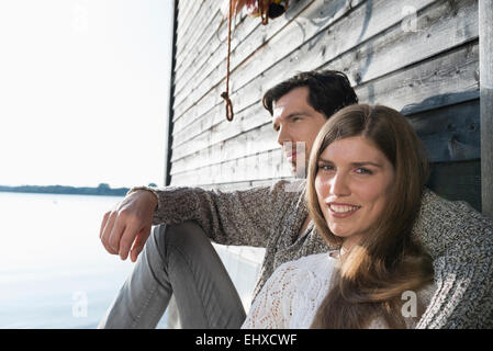 Young couple sitting boathouse wall portrait Stock Photo