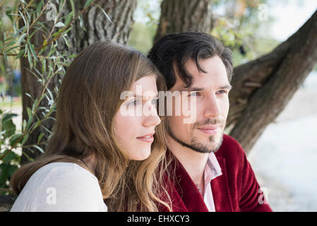 Close up portrait young couple sitting lake Stock Photo