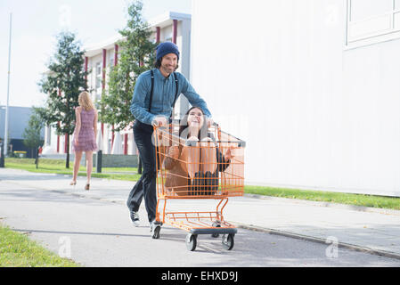 Young man pretending to kidnap businesswoman Stock Photo