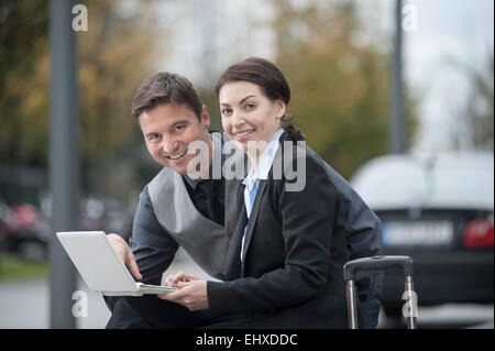 Travelling business executives working together on a laptop, Bavaria, Germany Stock Photo