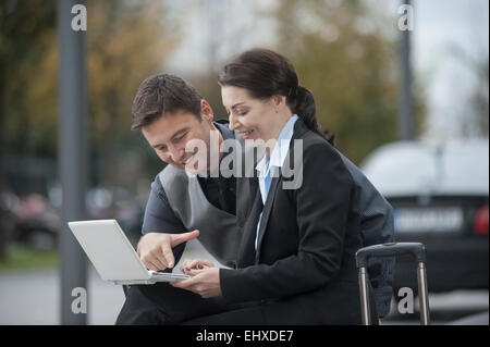 Travelling business executives working together on a laptop, Bavaria, Germany Stock Photo