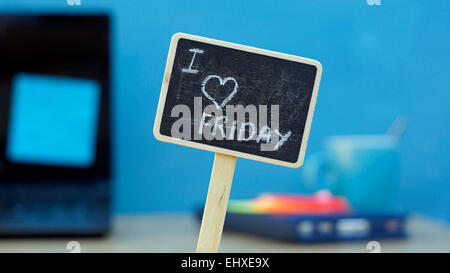 I love friday written on a chalkboard, in the background a office Stock Photo