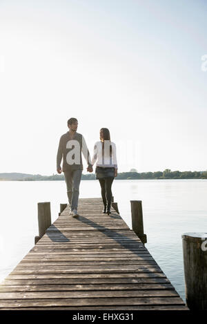 Young couple walking on wooden jetty