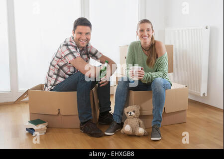 Couple taking a break from unpacking in their new home, Bavaria, Germany Stock Photo