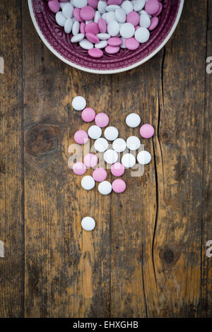 Pink and white chocolate buttons on wood Stock Photo