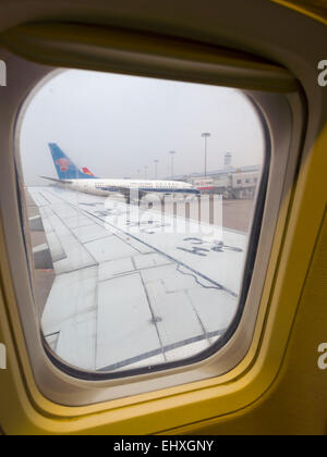 View out of the windows of an airplane at a China Southern airlines plane Stock Photo