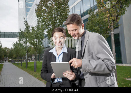 Two business executives working together on a digital tablet, Bavaria, Germany Stock Photo