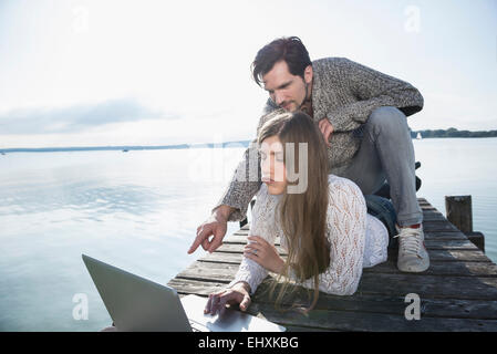 couple together lake outdoors working computer Stock Photo