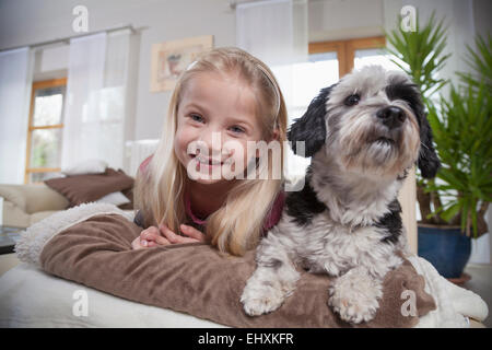 Girl with dog in a living room, Bavaria, Germany Stock Photo