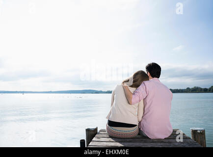 Romantic couple hugging lake jetty tranquil Stock Photo