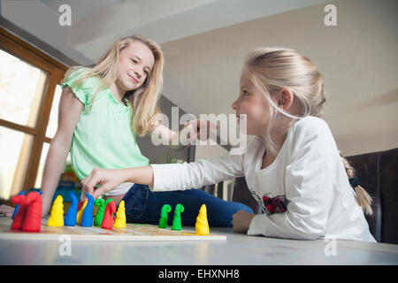 Two sisters playing board game, Bavaria, Germany Stock Photo