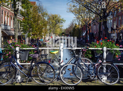 Bikes parked against the railings on a bridge over a canal in Delft, Netherlands. Stock Photo