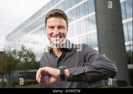 Businessman waiting outside an office building, Bavaria, Germany Stock Photo