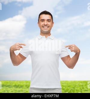 smiling man in t-shirt pointing fingers on himself Stock Photo