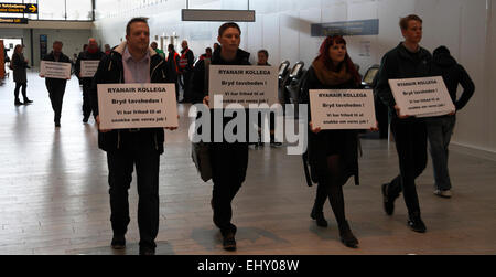 Copenhagen, Denmark. 18th March, 2014. The passengers for Ryanair’s first flight out of Copenhagen Airport were met by demonstrators in the check-in area in Terminal 2 not only from the flight crew unions, but from many supporting trade unions. Text on signs: 'RYANAIR COLLEAGUE: Break the silence! We are free to talk about our jobs!' The flight was delayed more than 3 hours in Copenhagen before returning to Dublin due to delayed handling and refuelling. The next meeting in the Danish Labour Court is 26th March. Credit:  Niels Quist/Alamy Live News Stock Photo