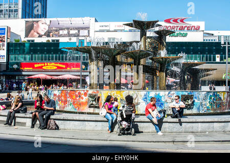 People cooling off around a fountain at Alexanderplatz in Berlin, Germany on a hot day. Stock Photo