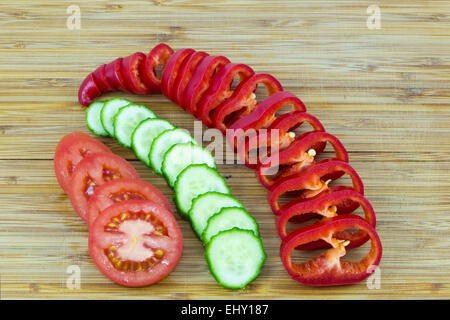 Sliced red and green vegetables on wooden background Stock Photo