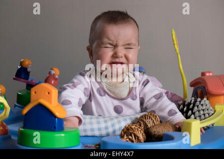 8 month old baby girl, in baby bouncer crying Stock Photo