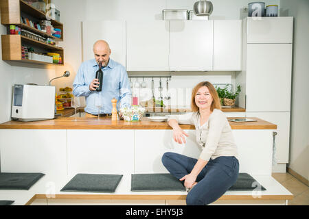 Senior man smelling wine cork in kitchen Stock Photo