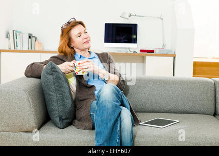 Senior woman having a cup of coffee at home Stock Photo