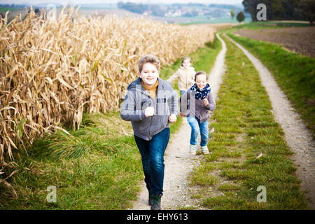 Three children running on path Stock Photo