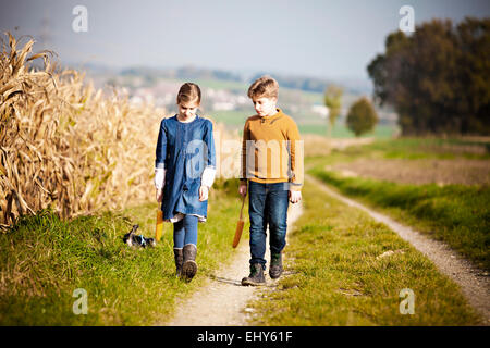 Girl and boy walking on path Stock Photo