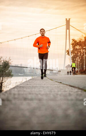 Man jogging on the waterfront at sunset Stock Photo