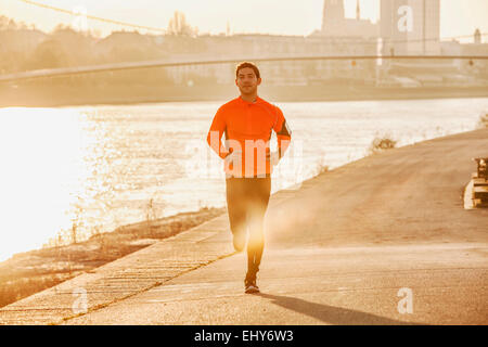 Man jogging on the waterfront at sunset Stock Photo