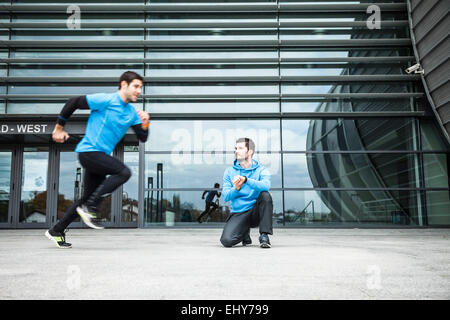 Male runners doing sprint training in city Stock Photo