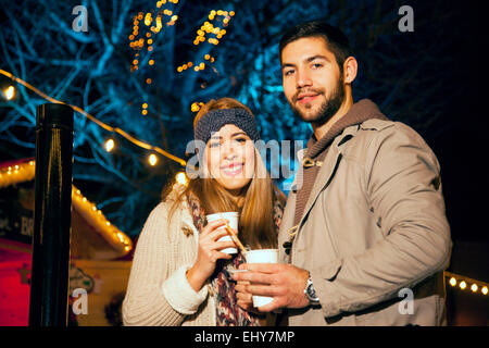 Young couple drinks punch at Christmas Market Stock Photo