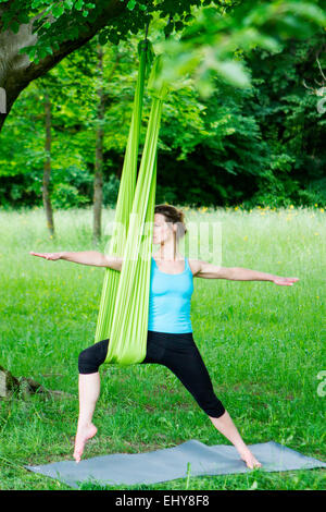 Young woman does stretching exercises with rubber band, Munich, Bavaria, Germany Stock Photo