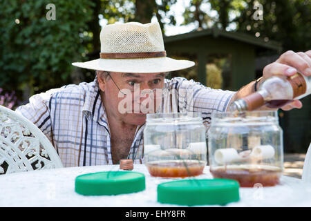 Senior man preparing snail trap, Bournemouth, County Dorset, UK, Europe Stock Photo