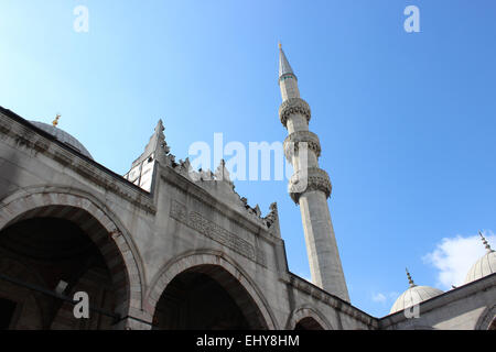 A view of the minaret and entrance of Yeni Cami (New Mosque) from the courtyard. Eminonu, Istanbul. Stock Photo