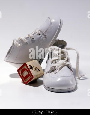 White baby shoes and baby block Stock Photo