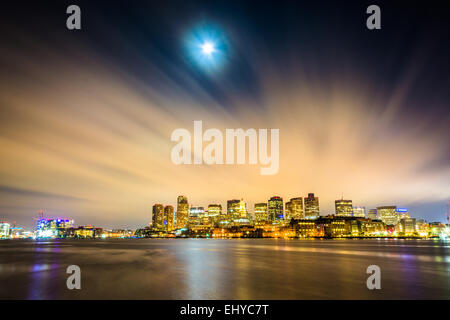 The moon and clouds moving through the sky over the Boston skyline at night, seen from LoPresti Park in East Boston, Massachuset Stock Photo