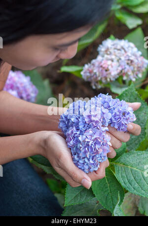 Young woman holding heart shaped flowers in her hand Stock Photo