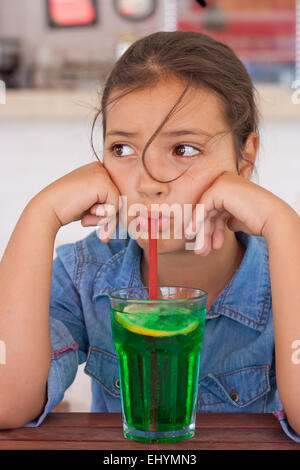 Grumpy girl drinking mocktail through a straw Stock Photo