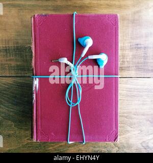 Headphones wrapped around an old book Stock Photo